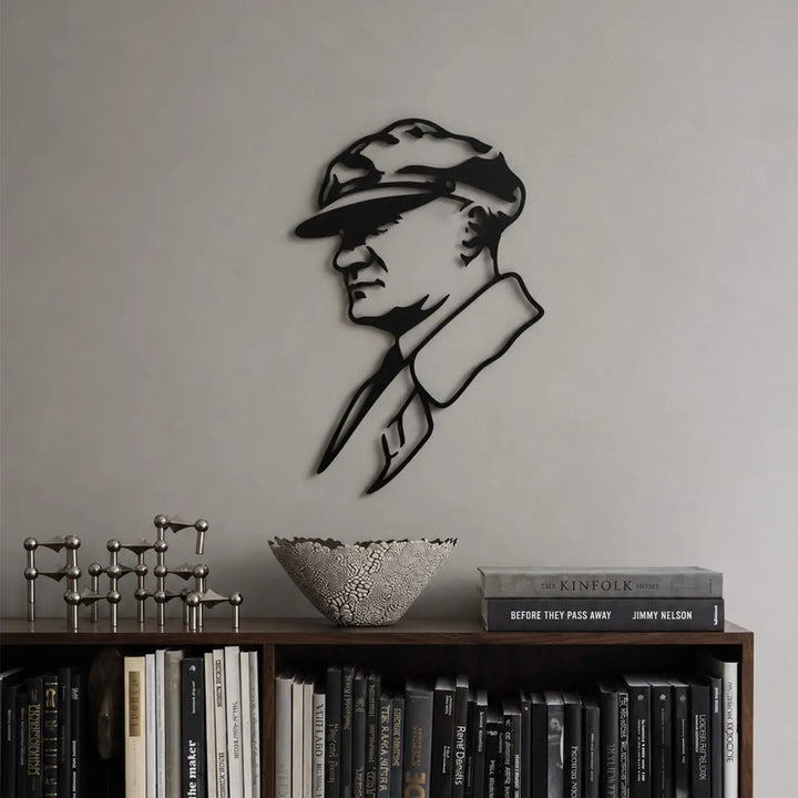 Atatürk profil tasarımlı siyah metal duvar tablosunun modern kitaplık ve yaşam alanında, raflı duvar dekorasyonuyla birlikte kullanımı.