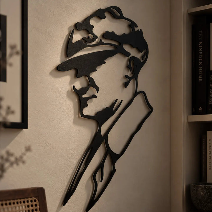 Atatürk profilinin yüz hatlarını, şapka ve yaka detaylarını oluşturan ince lazer kesim çizgilerinin ve siyah metal yüzeyin yakından görünümü.