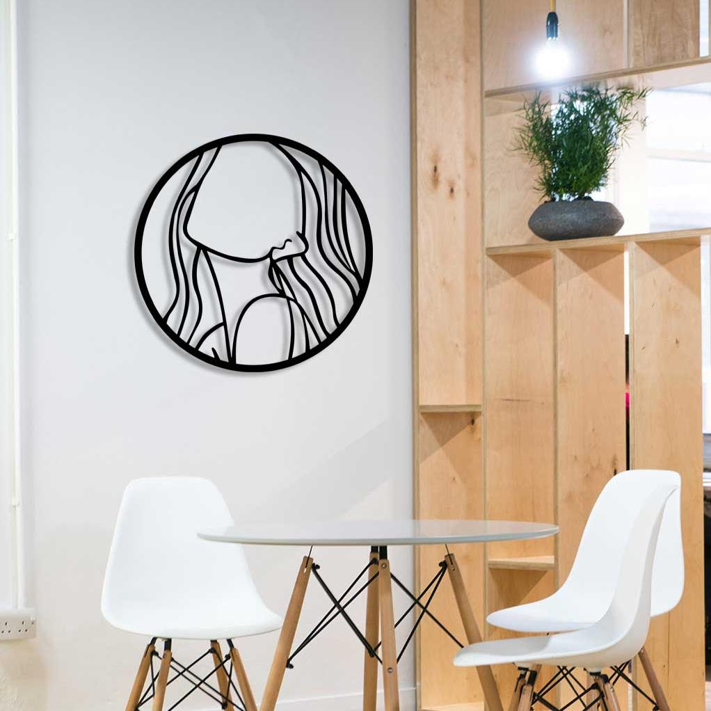 Modern bir iç mekanda, huzuru ve içsel dinginliği simgeleyen soyut kadın figürü formunda siyah metal duvar tablosu.