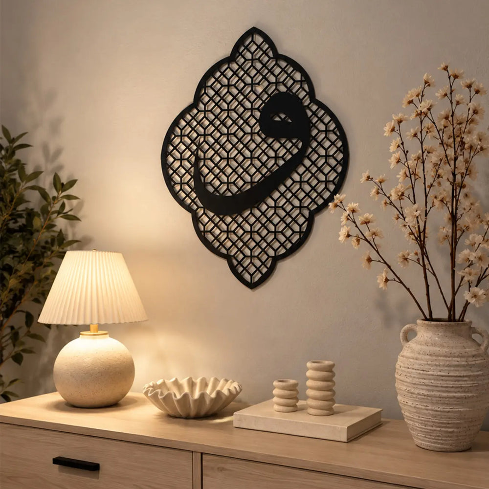 Vav Harfi Hat Sanatı Metal Duvar Tablosu, duvarda sergilenen geometrik desenli siyah metal formuyla oturma alanında yer alıyor.